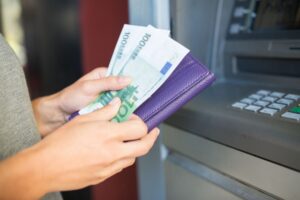 A person withdrawing Euros from a cash machine