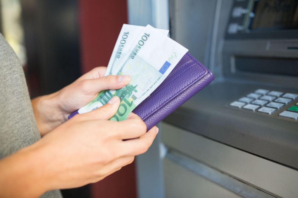 A person withdrawing Euros from a cash machine