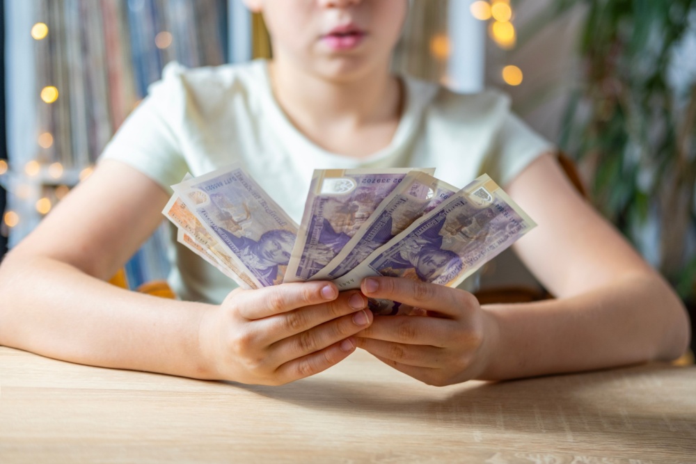 A young girl holding some cash