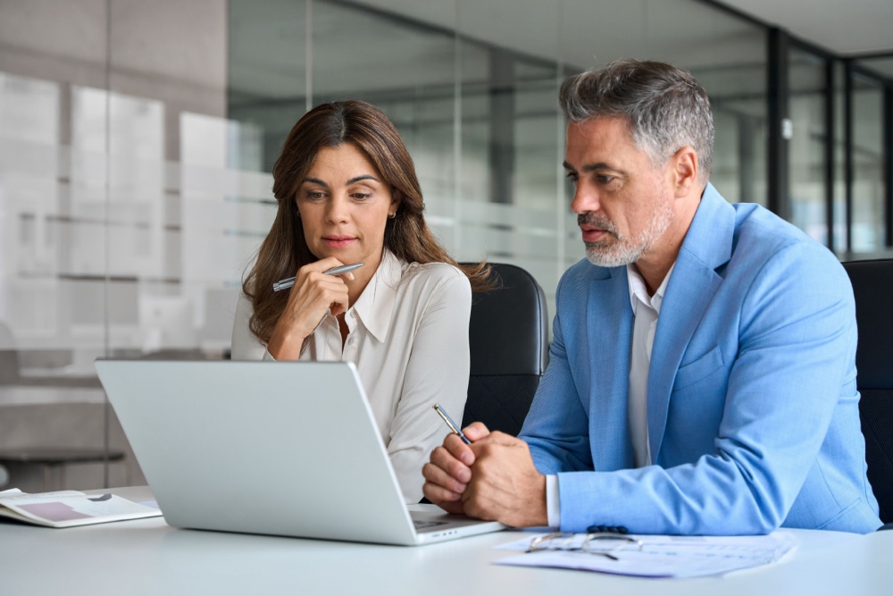 A man and a woman looking at a laptop